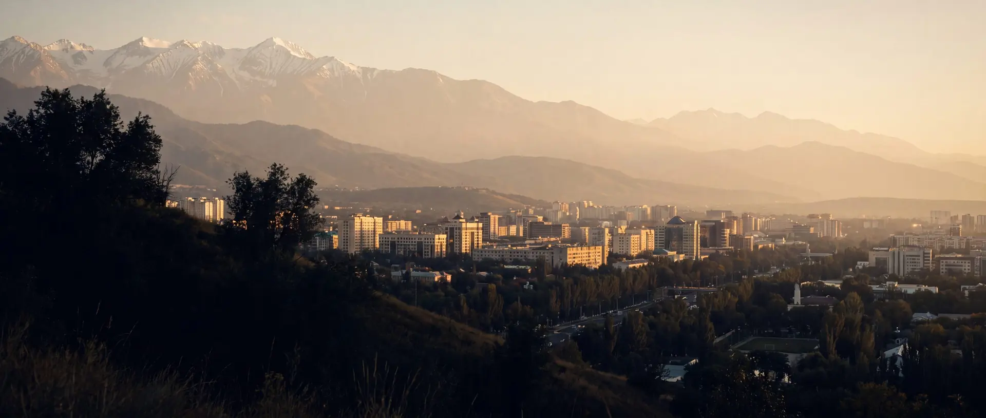Almaty city beneath the mountains at golden hour